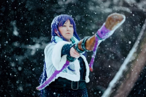 Fern (Amirine) in her winter outfit is pointing her staff diagonally towards the camera.